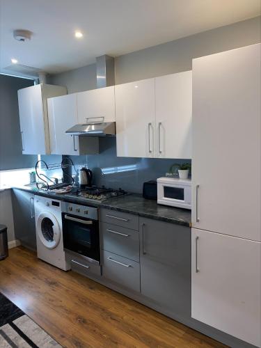 a kitchen with white cabinets and a stove top oven at Showcase Apartments – Kimberley House in Leicester