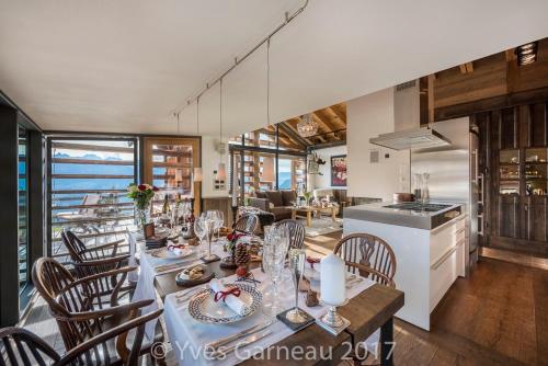 a dining room and kitchen with a table and chairs at Artsy Luxurious Ski-In-Out-Chalet in Bagnes