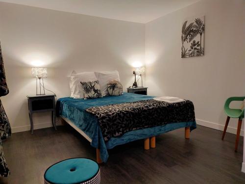 1 dormitorio con 1 cama con edredón azul en Gîte Eloquent, en Gratot