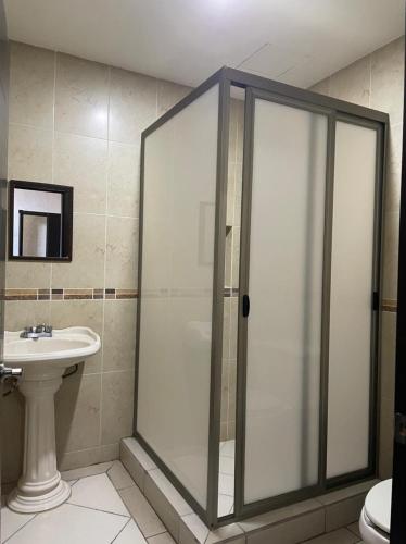 a bathroom with a shower and a sink at Hotel San Salvador in San Juan de los Lagos