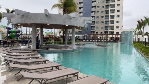 a swimming pool with lounge chairs in a resort at Salinas Exclusive Resort - Apto 1Q in Salinópolis