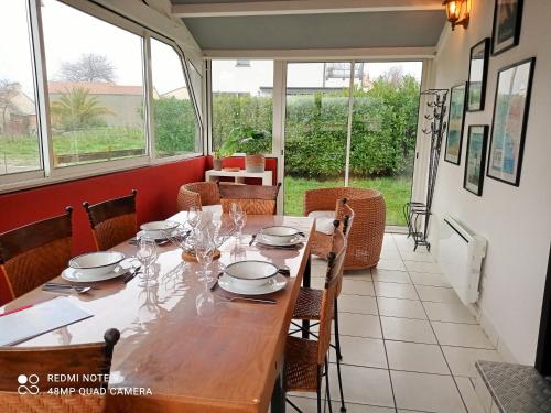 d'une salle à manger avec une table et quelques fenêtres. dans l'établissement Maison Mon Rêve à 400m de la plage, à Saint-Michel-Chef-Chef