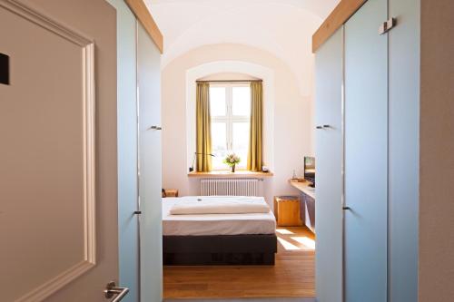 a bedroom with a bed and a window at Hotel Kloster Holzen in Allmannshofen