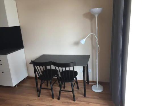 a black table with two chairs and a lamp at Žvėryno appartment-Self check-in-Free garage in Vilnius