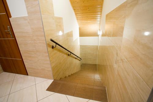 a hallway with a shower with a wooden wall at Karczma Chęciny in Chęciny