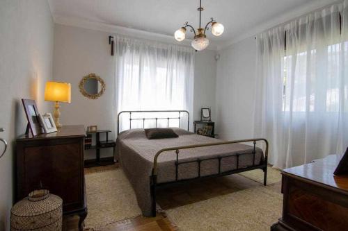een slaapkamer met een bed, een dressoir en een raam bij Casa Mió localizada em pleno centro histórico in Arcos de Valdevez