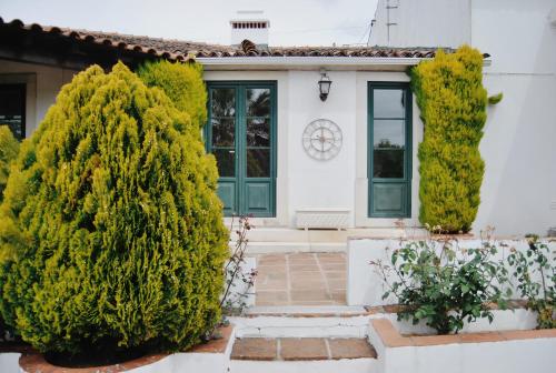 a white house with green doors and trees at Quinta de São Pedro de Tomar in Tomar