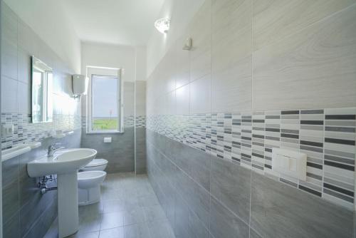 uma casa de banho branca com um lavatório e um WC em VILLAGGIO RESIDENCE EMMESSE em Zambrone