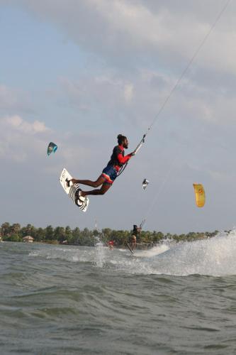 a man is in the air over the water at De Silva Palm Resort in Kalpitiya