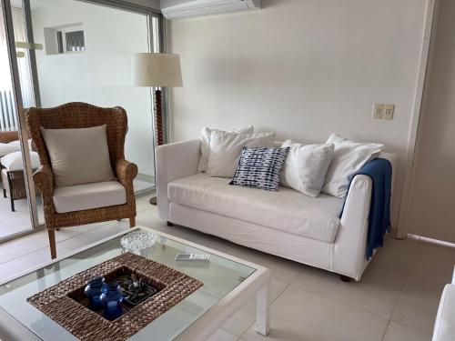 sala de estar con sofá blanco y silla en Sunset, en Punta del Este