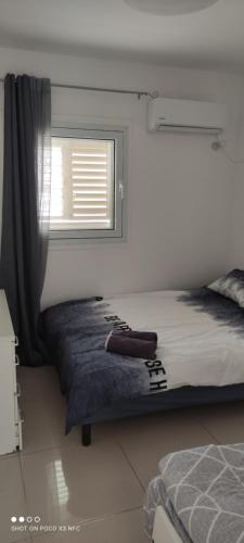 a bedroom with a bed and a window at Apartment with terrace and parking in Eilat