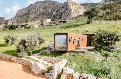 a house on the side of a hill with rocks at Container Suite in Terrasini