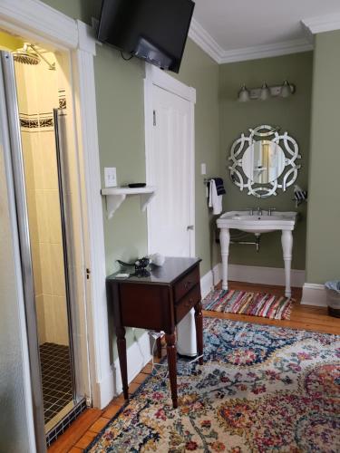 a bathroom with a sink and a mirror at The Jellybean Heritage Inn in St. John's