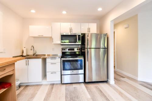 a kitchen with a refrigerator, stove, sink and a microwave at Chateau Riverside in Campbell River