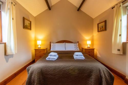 a bedroom with a bed with two towels on it at Laburnum Holiday Cottage in Tunstead