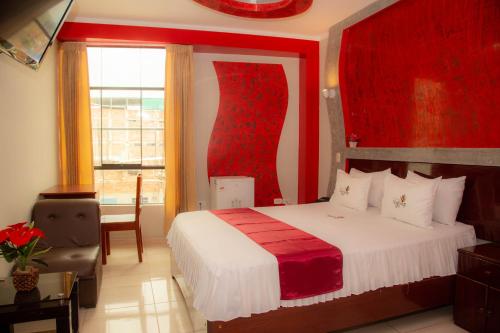 a bedroom with a red and white bed and a window at Hotel Suite Naylamp Zyon in Jaén
