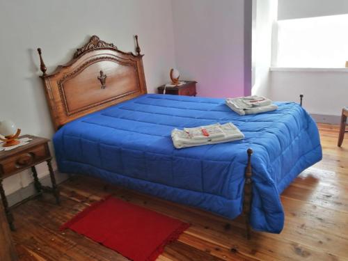 una camera da letto con un letto blu e asciugamani di Casa do Rossio a Fajazinha