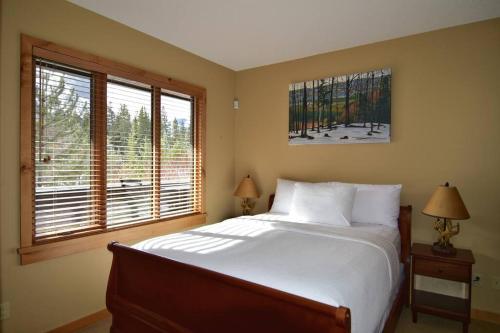 a bedroom with a bed and a large window at Luxurious Rundle Cliffs Lodge in Spring Creek in Canmore