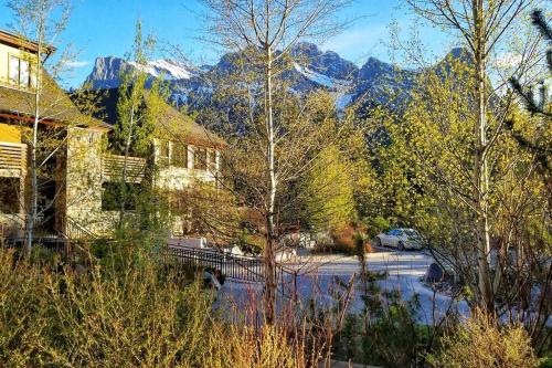 a snow covered mountain in the distance with a bench at Luxurious Rundle Cliffs Lodge in Spring Creek in Canmore