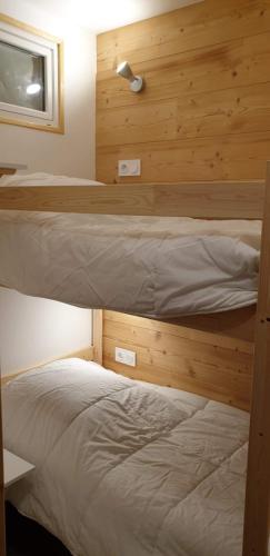 two bunk beds in a room with wooden walls at 2 Appt 4 à 6 pers Val Louron au pied des pistes in Génos
