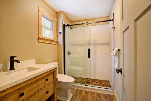 a bathroom with a shower and a toilet and a sink at The Lodge by Sunapee Stays in Sunapee
