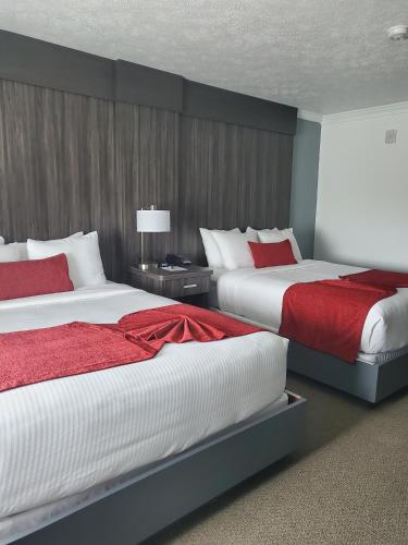 a bedroom with two beds with red and white sheets at Sequoia Inn in Hanford