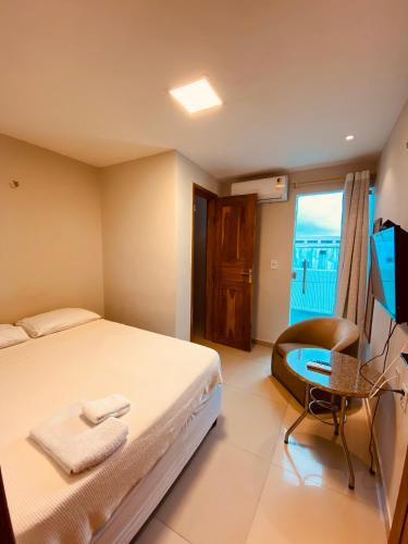 a bedroom with a bed and a desk and a television at Hotel Clin Acaraú in Acaraú
