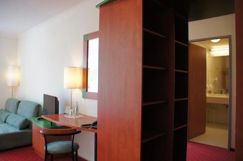 a hotel room with a desk and a room at EuroHotel Günzburg in Günzburg