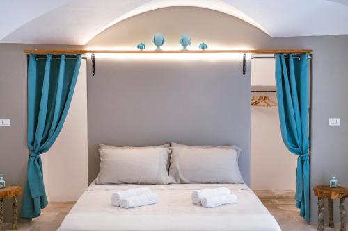 a bedroom with a bed with blue curtains at Via Roma 32 in Ostuni
