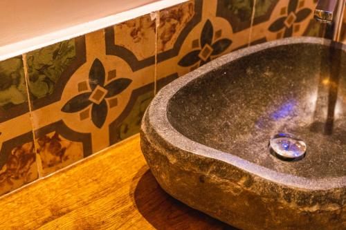 a bathroom with a large stone sink on the floor at Via Roma 32 in Ostuni