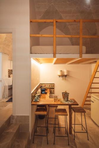a small kitchen with a table and stools at Via Roma 32 in Ostuni