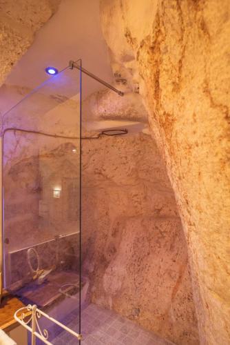 a shower in a cave with a rock wall at Via Roma 32 in Ostuni