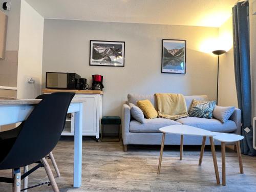 un salon avec un canapé et une table dans l'établissement Centre ville, T2 avec terrasse et parking couvert., à Cauterets