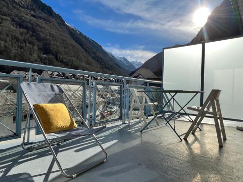 balcón con sillas, mesa y vistas a la montaña en Centre ville, T2 avec terrasse et parking couvert. en Cauterets