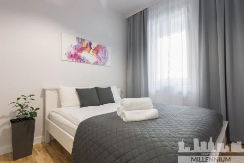 a bedroom with a bed with two pillows on it at Millennium Awangarda Grey in Warsaw