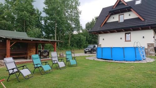 a group of chairs in a yard next to a house at Jurgowski Domek in Jurgów
