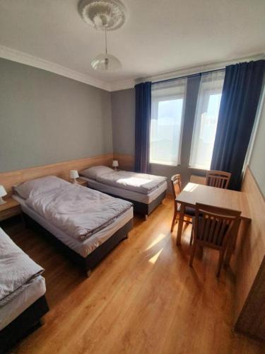 a room with two beds and a table and chairs at Lux Resort in Kraśnik
