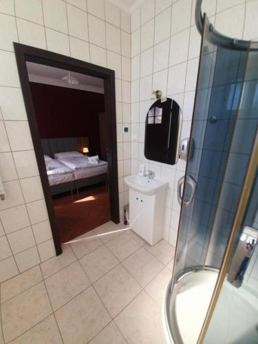 a bathroom with a shower and a bed in a room at Lux Resort in Kraśnik