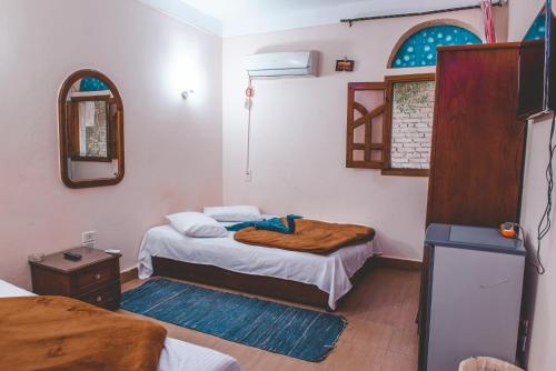 a small room with two beds and a mirror at Gina Motel Dahab in Dahab