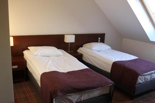 a hotel room with two beds and a window at Hotel Marusza in Grudziądz