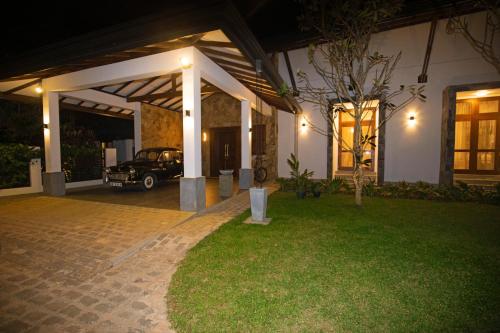 a house with a car parked in a yard at night at Anodawa Boutique Villa in Tangalle
