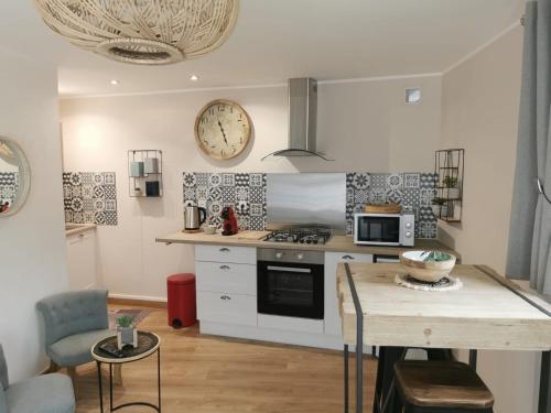 cocina con mesa y reloj en la pared en Superbe studio cocooning au cœur de la Sologne., en Nouan-le-Fuzelier
