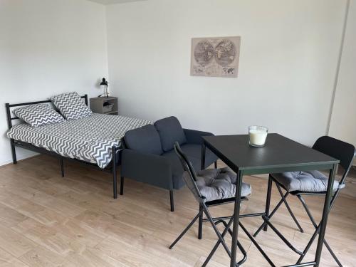 une chambre avec un lit, une table et des chaises dans l'établissement L'essentiel, à Noyal-sur-Vilaine