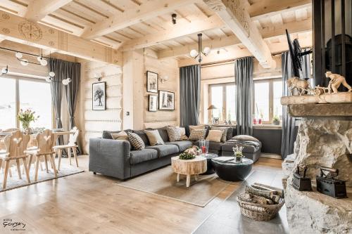 a living room with a couch and a fireplace at Luxury Chalet Villa Gorsky Hanco & Janso in Poronin