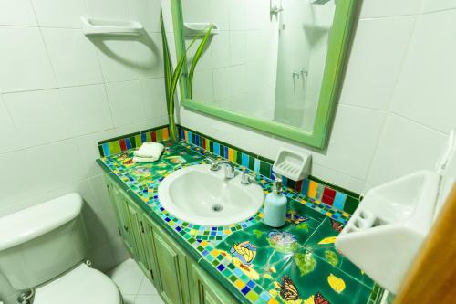 W łazience znajduje się umywalka, lustro i toaleta. w obiekcie Hotel Casa Esencia w mieście Medellín