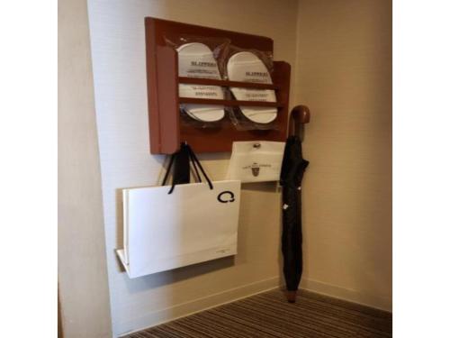 a black umbrella and a bag on a wall at The QUBE Hotel Chiba - Vacation STAY 02227v in Chiba
