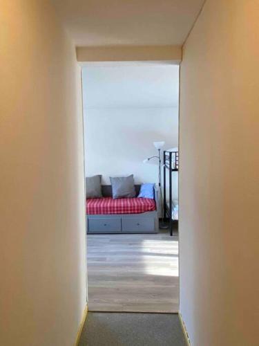 um corredor com um sofá vermelho num quarto em Studio 4 personnes résidence la Souce em Laguiole