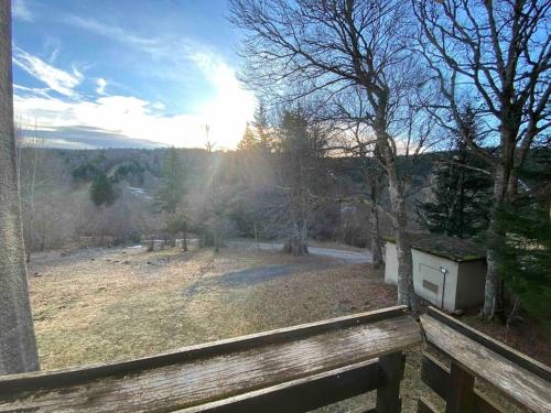 a view of a field with a wooden bench at Studio 4 personnes résidence la Souce in Laguiole