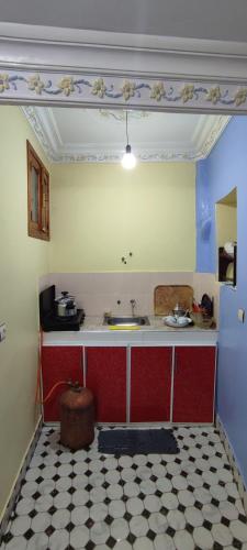 a kitchen with a red and white tile floor at Casa Lotfi 1 in Chefchaouene