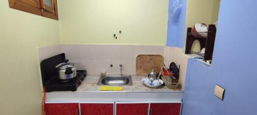 uma pequena cozinha com um lavatório no canto em Casa Lotfi 1 em Chefchaouene